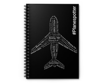 May include: Black spiral notebook with a white airplane silhouette made of airplane model names, such as Airbus A380, Boeing 787, and Boeing 747. The text "#Planespotter" is on the right side of the notebook.