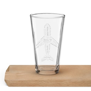 May include: A clear glass with a design of an aeroplane made from the names of different aeroplane models, including Airbus A380, Boeing 787, Boeing 747, Boeing 737, and Airbus A320.