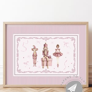 May include: A framed print featuring watercolor illustrations of a mouse, a nutcracker, and a ballerina in pink and brown tones. The artwork is set against a pink striped background with a decorative border, and is in a light brown wooden frame.