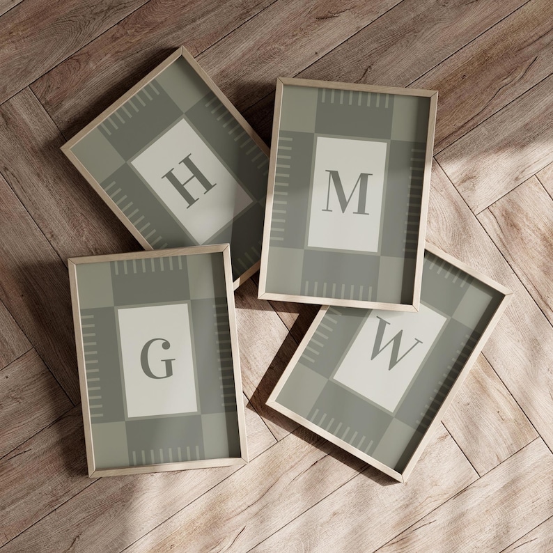 May include: Four framed art prints with the letters G, H, M, and W. Each print features a light green and gray plaid pattern with a white central rectangle containing a single letter. The frames are light wood.