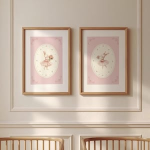 May include: Two framed prints featuring a watercolor illustration of a bunny wearing a tutu and holding flowers. The bunny is centered on a pink oval, surrounded by decorative flourishes, and set against a pink background. The frames are made of light brown wood.