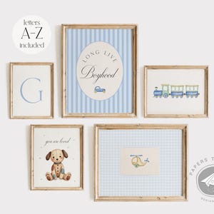 Puede incluir: Un conjunto de seis impresiones enmarcadas con patrones azules y blancos. Las impresiones presentan ilustraciones de un coche de juguete, un tren, un helicóptero, un perro y las palabras "Long Live Boyhood" y "G".