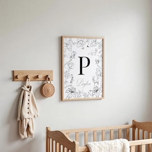 May include: A black and white nursery print with a floral border and a large letter "P" in the centre. The name "Payton" is written below the letter. The print features various animals including a bear, fox, deer, and rabbit.