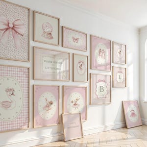 May include: A collection of framed wall art in shades of pink and white, featuring various designs such as a swan, a ballerina, a bow, and the text "Thank Heaven for Little Girls". The frames are light wood.
