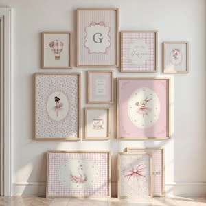 May include: A collection of framed art prints in a nursery theme. The prints feature illustrations of a hot air balloon, a ballerina, a swan, and a bunny, all in soft pink and white tones. Some prints include text, and all are in wooden frames.