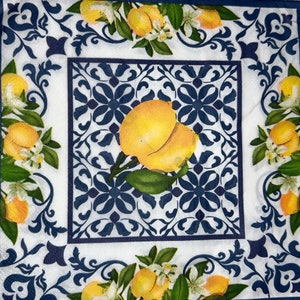 May include: Square decorative napkin with a lemon and floral design. The center features a pair of yellow lemons with green leaves against a blue and white tile pattern. The border has lemons, white flowers, and blue scrollwork.