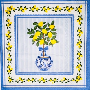 May include: Square paper napkin with a lemon tree design. The tree, in a blue and white pot, is centered on a white background with vertical stripes. A blue border frames the design, with a decorative lemon and leaf pattern.