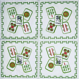 May include: Four white square paper napkins featuring a green bamboo-style border. Each napkin displays a central Joker mahjong tile with a panda illustration and the text Joker, surrounded by four other mahjong tiles with bamboo and floral motifs.