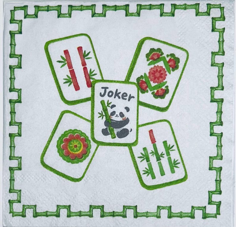 May include: A white square paper napkin featuring a green bamboo-style border. The center displays five Mahjong tiles arranged in a cross pattern. The central tile shows a panda holding bamboo with the text Joker, surrounded by four tiles.