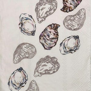 May include: White napkin with a pattern of various oyster illustrations. The oysters are depicted in shades of gray, brown, and purple, with detailed shell textures. The napkin has a subtle, textured surface.