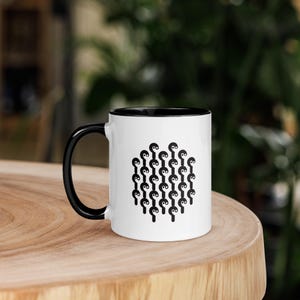 May include: White ceramic mug with a black rim and handle. The mug features a black and white yin yang symbol pattern.