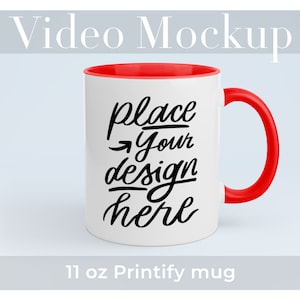 May include: White ceramic mug with a red rim and handle. The mug has black text that says "place your design here". 11 oz Printify mug.