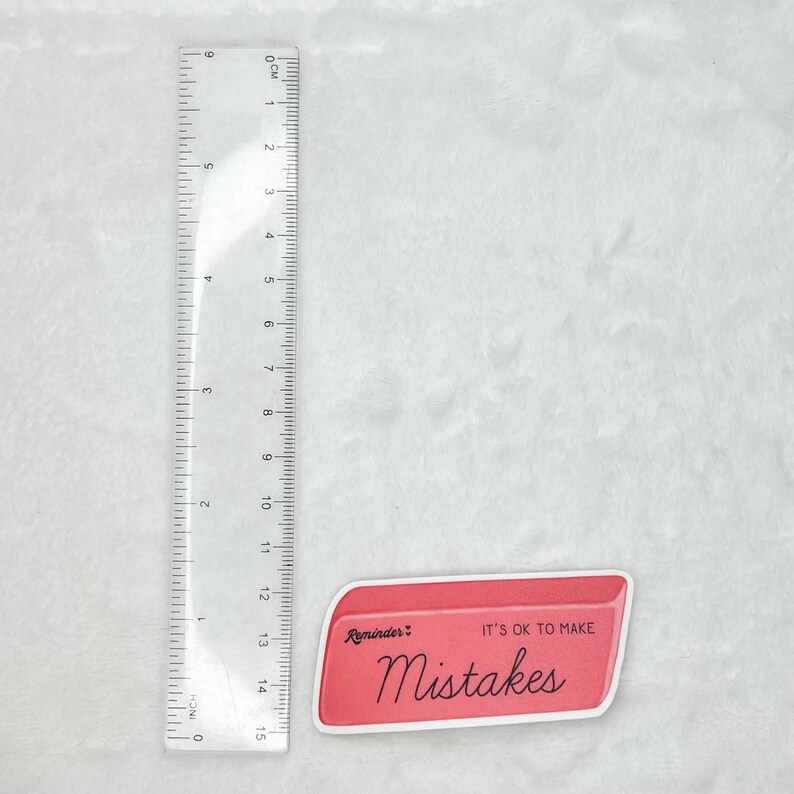 May include: A pink eraser sticker with the text "Reminder: It's OK to Make Mistakes" in black lettering.