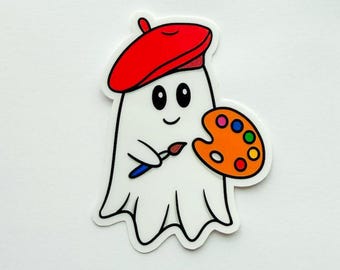 May include: A white ghost-shaped sticker wearing a red beret, holding a paintbrush and a colourful artist's palette. The sticker has a black outline and a smiling face. The theme is art and Halloween.