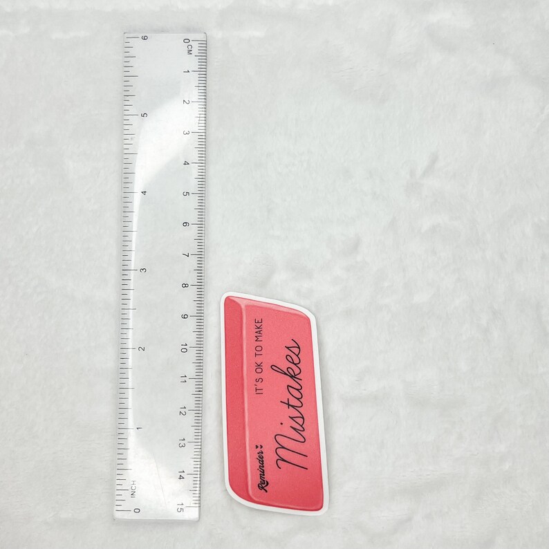 May include: A pink eraser with the text "Reminder: It's OK to make Mistakes" in black cursive writing.