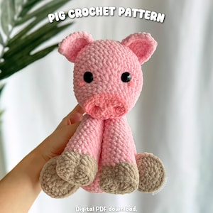 May include: A handmade pink crochet pig with a light pink snout and ears, and tan hooves. The pig has black eyes and is sitting upright. The text "PIG CROCHET PATTERN" is at the top, and "Digital PDF download" is at the bottom.