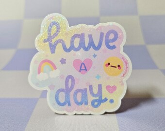 May include: A holographic sticker with the words "have a day" in a whimsical font. The sticker features a rainbow, heart, stars, and a smiling face. The background is a checkered pattern.