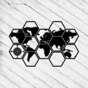 May include: Black and white world map art piece. The map is segmented into hexagonal shapes, with a compass rose in the lower left corner. The continents are solid black against a white background, creating a striking contrast. The piece is mounted on a white wooden surface.