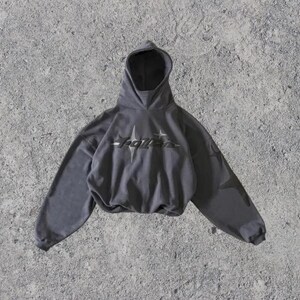 Puede incluir: Una sudadera con capucha gris recortada con un gr&aacute;fico negro que dice "Roller" en la parte delantera.
