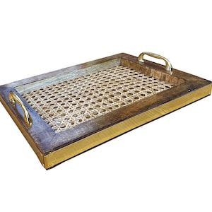 Puede incluir: Bandeja rectangular para servir con un centro de ratán tejido y un marco de madera oscura. La bandeja tiene asas y ribetes dorados. Una pieza elegante para servir bebidas o exhibir artículos.