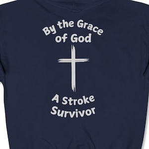 May include: Navy blue hooded sweatshirt with a white cross and the text "By the Grace of God A Stroke Survivor".