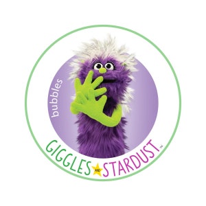 May include: A purple and white furry puppet with a green hand, in a circle with the text "Giggles and Stardust" and "Bubbles" written vertically.