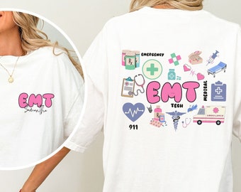 May include: White oversized t-shirt with a pink "EMT" graphic on the front and a colorful graphic of medical symbols and the text "EMT" on the back.