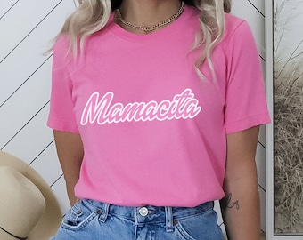 May include: A pink t-shirt with the word "Mamacita" printed in white on the front.
