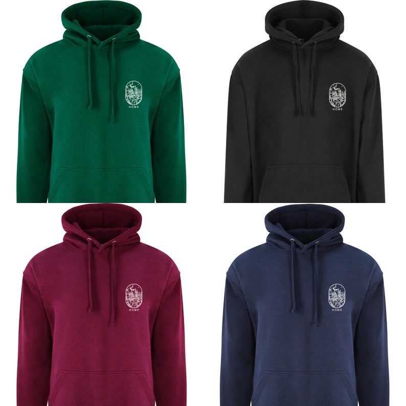 K&ouml;nnte beinhalten: Vier Kapuzenpullover in verschiedenen Farben: gr&uuml;n, schwarz, burgunderrot und marineblau. Jeder Pullover zeigt eine wei&szlig;e Grafik einer Waldszene mit dem darunter gedruckten Wort "HOME".