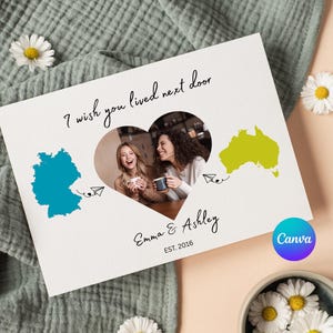 Könnte beinhalten: Eine weiße Karte mit dem Text "I wish you lived next door" und einem herzförmigen Foto von zwei Frauen. Die Karte zeigt blaue und gelbe Umrisse von Ländern, die Namen "Emma & Ashley" und das Jahr "2016".