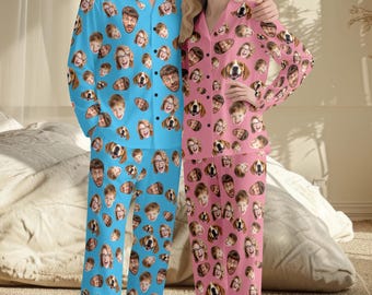 May include: A set of long-sleeved button-down pajamas in bright blue and soft pink, both featuring an all-over repeating pattern of various human faces and dog faces printed across the fabric of the shirts and matching pajama pants.
