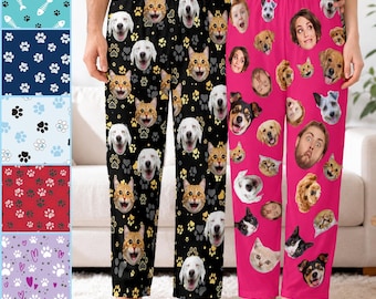 May include: Two pairs of pajama pants. One pair is black with a repeating pattern of dog and cat faces and yellow paw prints. The other pair is bright pink with a repeating pattern of various dog, cat, and human faces.