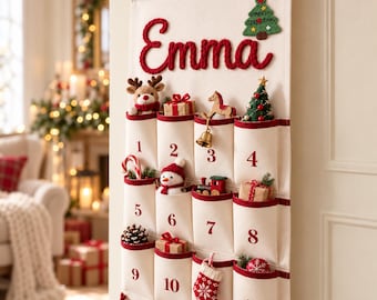 May include: A cream-colored fabric advent calendar hanging from a wooden rod, featuring the name Emma in red yarn. It has twelve numbered pockets with red trim, each containing small holiday ornaments like a reindeer, snowman, and gifts.
