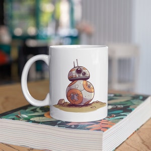 May include: White ceramic mug with a cartoon illustration of a white and orange robot with black eyes. The robot is standing on a brown surface.