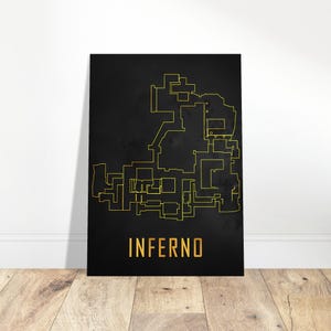 May include: A black poster featuring a gold outline map and the word "INFERNO" in gold. The map is a detailed outline of a complex structure. The poster is leaning against a white wall on a wooden floor.