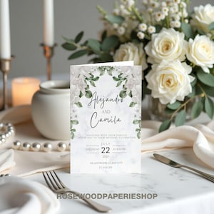 Puede incluir: Invitación de boda con fondo de mármol y diseño floral. La invitación dice "Alejandro y Camila" con la fecha "22 de julio de 2025" y la hora "8:00 PM".