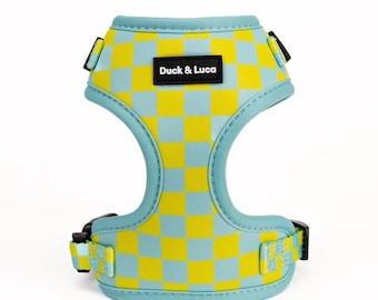 Può includere: Un'imbracatura per cani a scacchi blu e gialla con un'etichetta nera che recita "Duck & Luca".