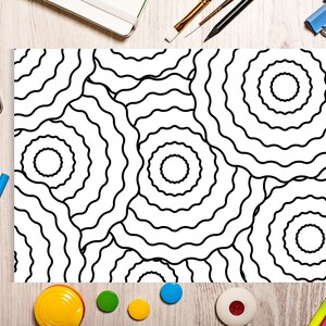 May include: A black and white coloring page with a repeating pattern of wavy circles. The page is surrounded by art supplies, including crayons, paint, and a pencil.