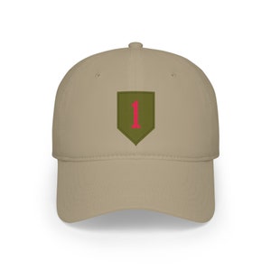 May include: A tan baseball cap featuring a green and pink patch with the number 1. The cap has a curved brim and a structured crown. The patch is a shield shape with a pink number 1 in the center.