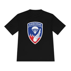 May include: Black t-shirt with a white, blue and red patch featuring a parachute and a wing. The patch says "AIRBORNE" in white letters.