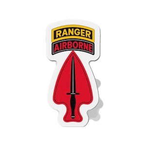 May include: A die-cut sticker featuring the U.S. Army Ranger Airborne insignia. The design includes a yellow tab with the word RANGER in black, a black tab with the word AIRBORNE in red, and a red arrowhead shape containing a black dagger.