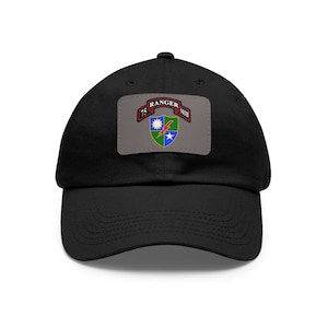 Op de afbeelding: Zwarte baseballcap met een rechthoekige patch met de tekst "75 RANGER MIB" en een kleurrijk embleem. Het embleem bevat een zon, een bliksemschicht en een ster.