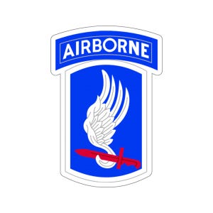 Puede incluir: Un parche azul y blanco con la palabra "AIRBORNE" en letras blancas sobre una pancarta azul. Un ala estilizada blanca con una daga roja sobre un fondo azul.