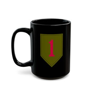 Peut inclure: Une tasse en céramique noire avec une grande anse. La tasse présente un motif de bouclier vert olive avec le chiffre 1 en rouge. La tasse est de taille standard.