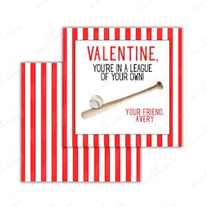 Puede incluir: Tarjeta de San Valentín con temática de béisbol. La tarjeta presenta rayas rojas y blancas y el texto "VALENTINE, YOU'RE IN A LEAGUE OF YOUR OWN!" con una ilustración de béisbol y bate. La tarjeta está firmada "YOUR FRIEND, AVERY."
