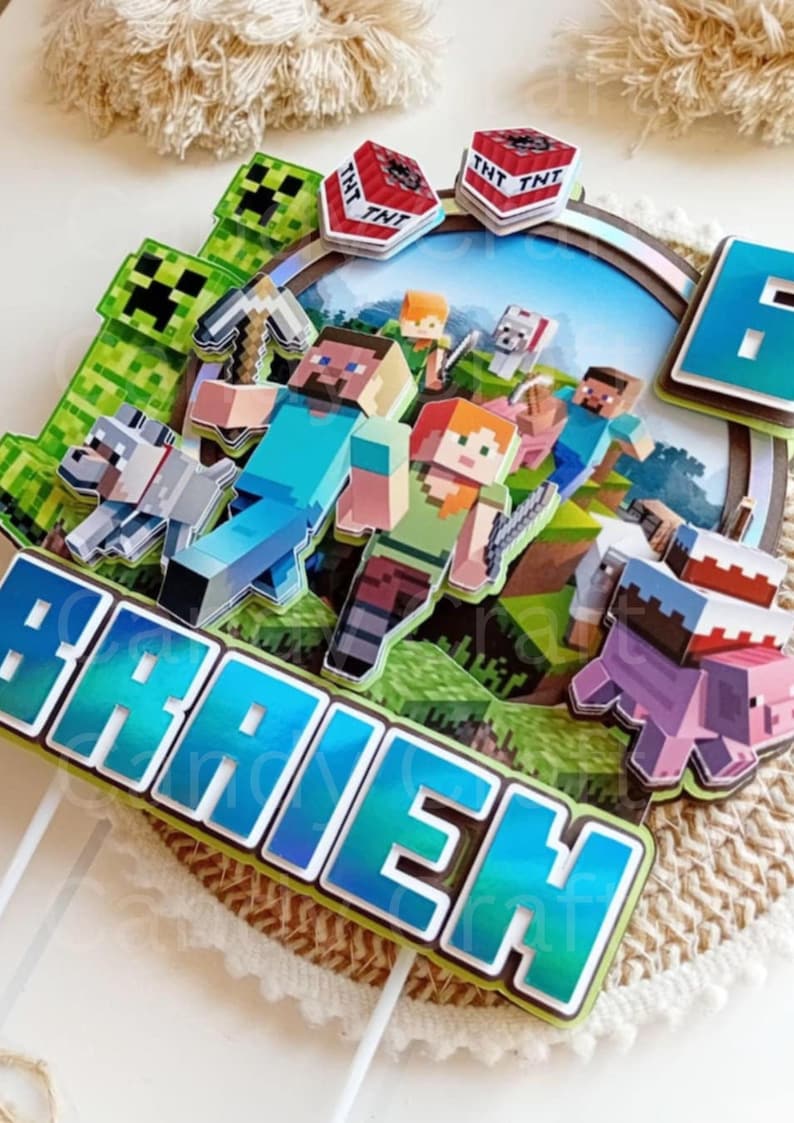 May include: A Minecraft themed cake topper with a blue and green iridescent finish. The topper features a group of Minecraft characters, including Steve, Alex, and a pig. The topper also includes a TNT block and a creeper. The name "Braden" is written in blue and green iridescent letters.