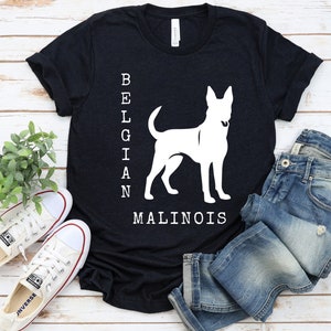 May include: A black t-shirt with a white silhouette of a Belgian Malinois dog and the text "BELGIAN MALINOIS" printed on the front.