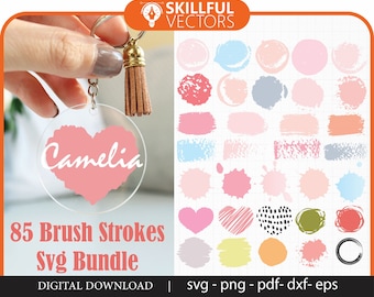 Pode incluir: Um download digital de 85 arquivos SVG de pinceladas. A imagem mostra uma variedade de pinceladas nas cores rosa, azul e verde. O texto "Camelia" está escrito em branco sobre uma pincelada rosa em forma de coração.