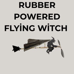 May include: A whimsical, rubber-powered flying witch toy. The black silhouette of a witch on a broom is attached to a propeller and a wing-like structure. The text "RUBBER POWERED FLYING WITCH" is displayed above the toy.