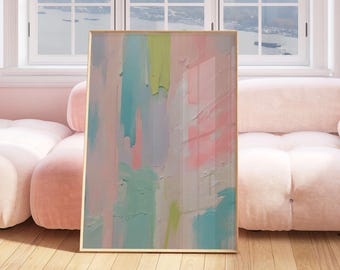 Op de afbeelding: Abstracte kunstafdruk in een gouden lijst. Het kunstwerk toont verticale penseelstreken in pastelkleuren, waaronder roze, blauw, groen en wit. Het schilderij wordt tentoongesteld in een lichte kamer met een roze bank en houten vloer.